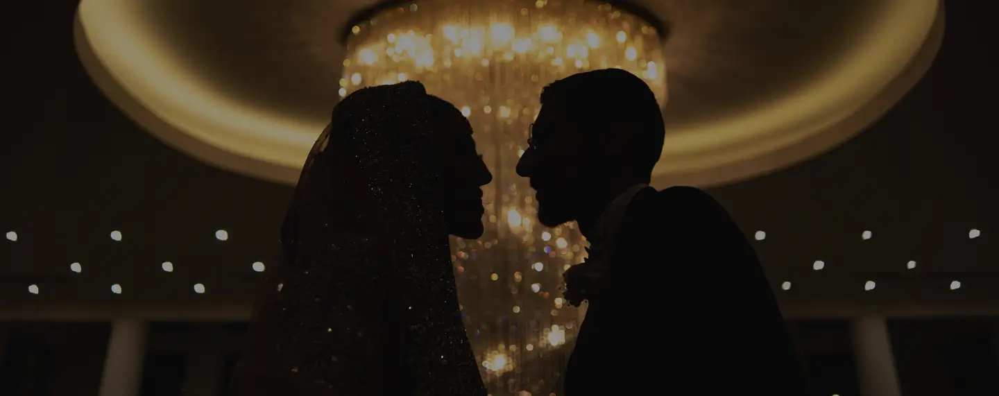 Couple silhouetted beneath a chandelier at Meridian Grand — luxury wedding venue London.