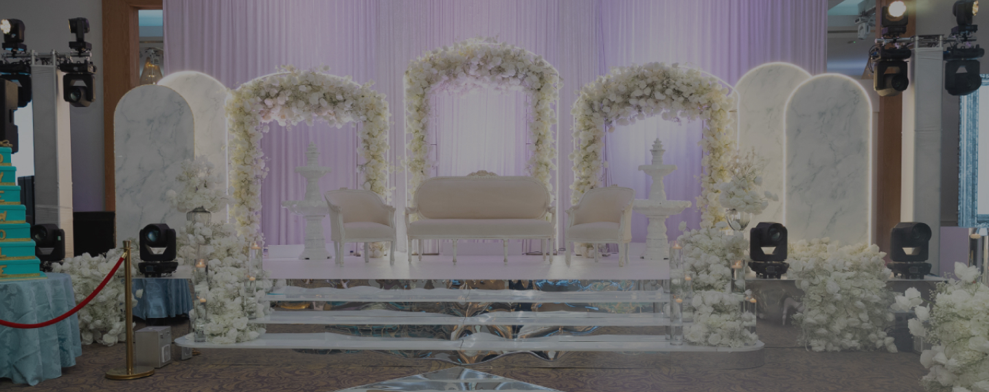 White floral ceremony arch and staircase set for an African wedding at Meridian Grand — African wedding venue London.