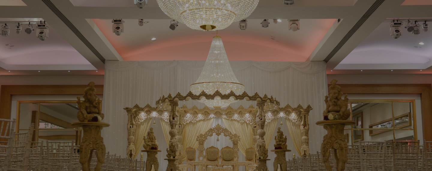 Couple on a gold mandap at a Hindu wedding at Meridian Grand — Hindu wedding venue London.