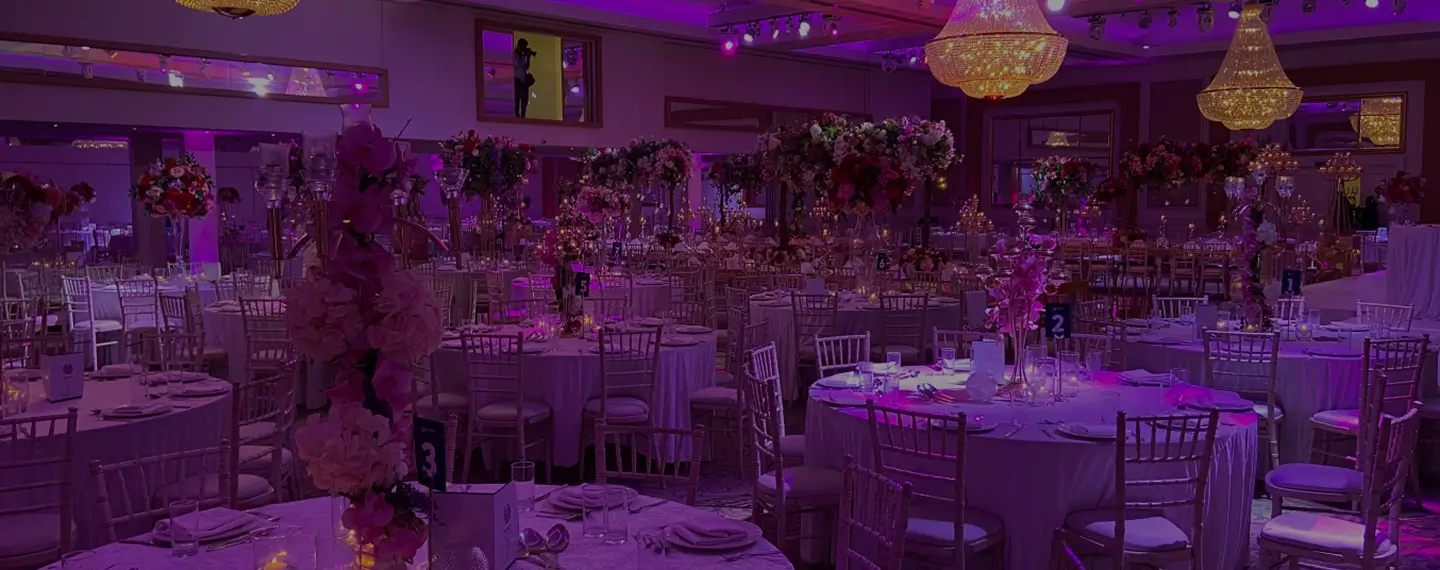 Ballroom set with round tables and tall floral centrepieces at Meridian Grand — wedding and events venue London.